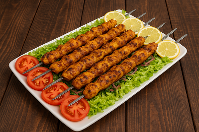 Lemon garlic chicken skewers plated with side salad and dipping sauce