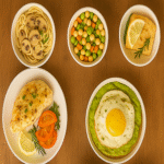 Flavor-packed meal plan featuring a top-down view of ten vibrant global dishes arranged in small bowls on a wooden table.