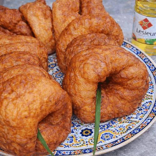Moroccan sfenj fried doughnuts served on traditional decorative plate