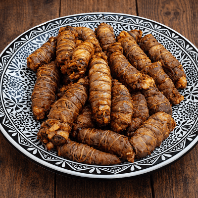 Moroccan kerdas stuffed lamb offal rolls served on traditional black and white plate