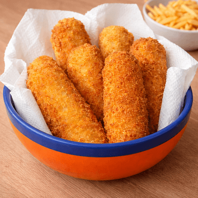 Crispy fried croquettes served in blue and orange bowl with fries in background